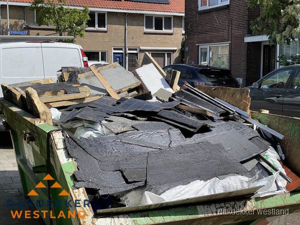 Afvalcontainer met gesloopt dakmateriaal tijdens dakkapel renovatie in Westland