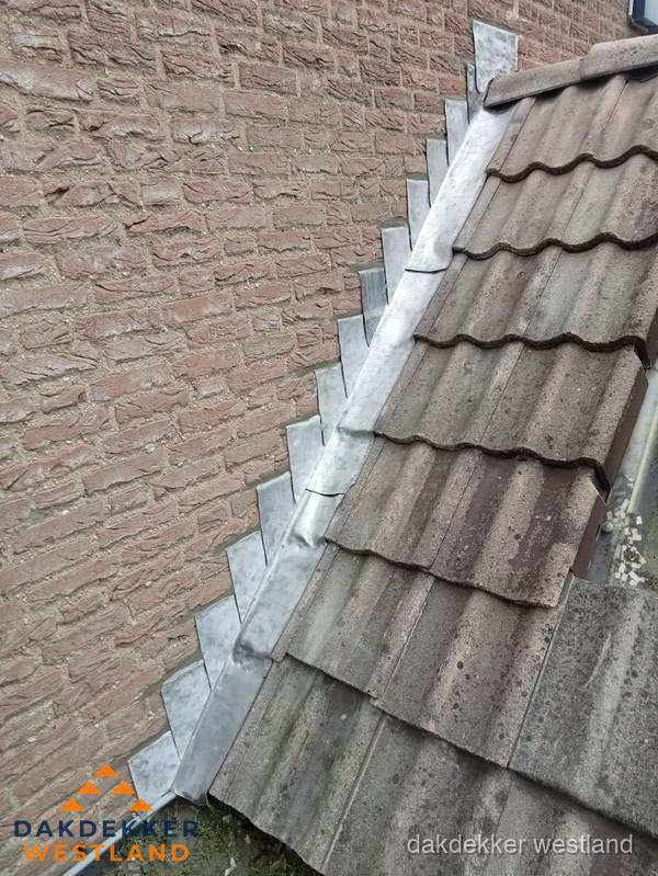 Loodslabben langs dakaansluiting bij bakstenen muur in Westland Loodslabben langs dakaansluiting bij bakstenen muur in Westland