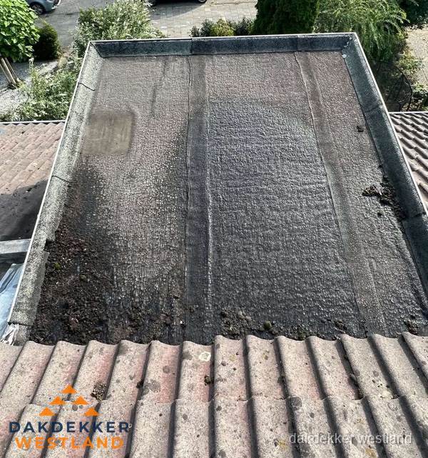 Verouderd plat dak met bitumen en slijtage voor lekkage inspectie in Westland Verouderd plat dak met bitumen en slijtage voor lekkage inspectie in Westland