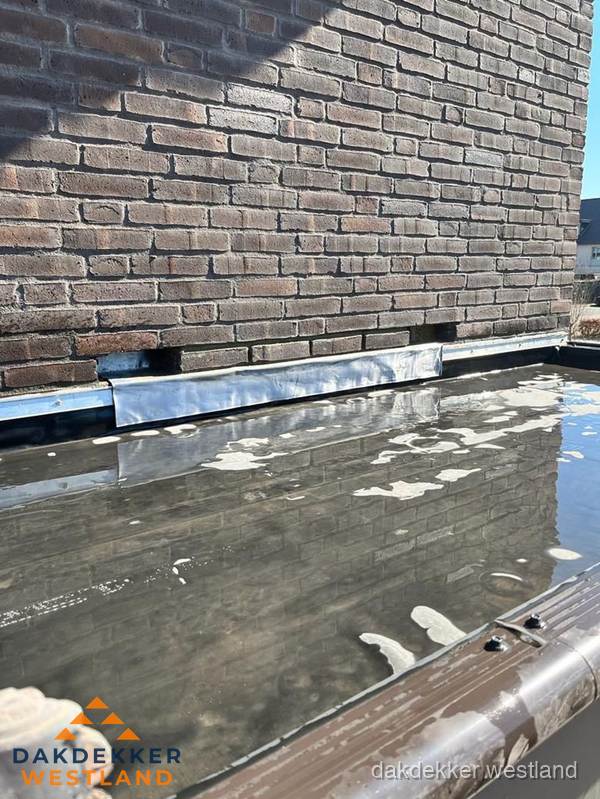 Stilstaand water op plat dak door slechte afwatering in Westland Stilstaand water op plat dak door slechte afwatering in Westland