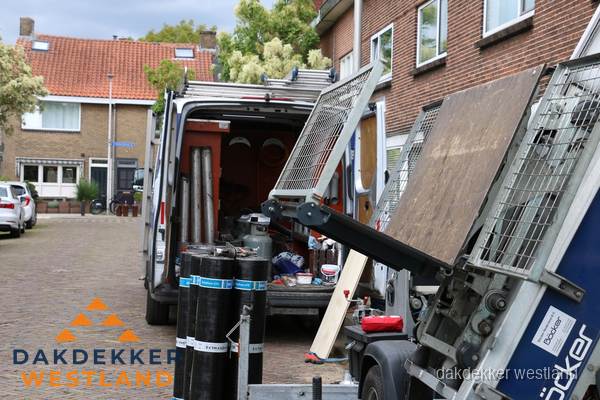 Dakdekkersbusje met materiaal en ladderlift voor dakpannen vervangen in Westland